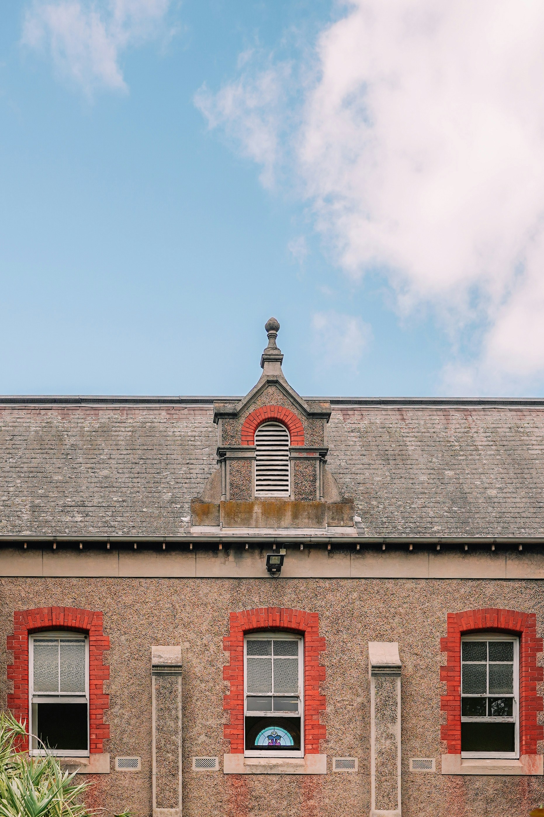 un bâtiment en briques rouges avec une horloge sur le dessus