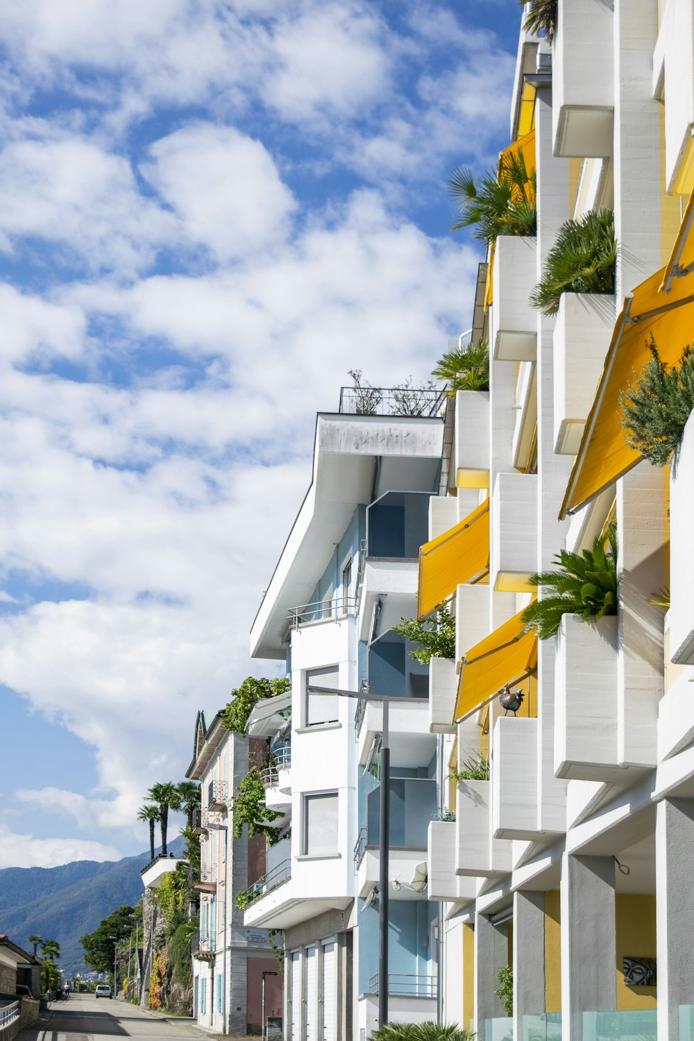 a row of white buildings with yellow balconies