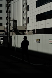 Close-up of pixel art character standing in a shadowy urban environment.