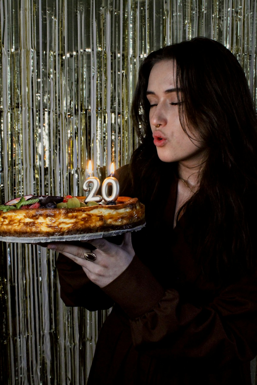 a woman holding a cake with candles in it