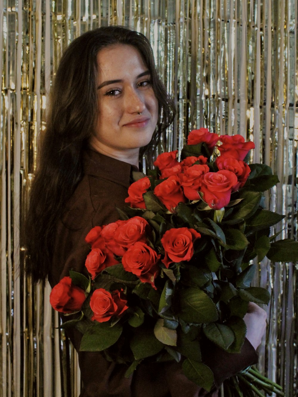 a woman holding a bouquet of red roses