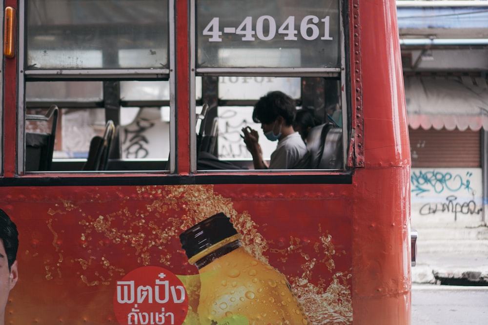 a man standing in front of a red bus