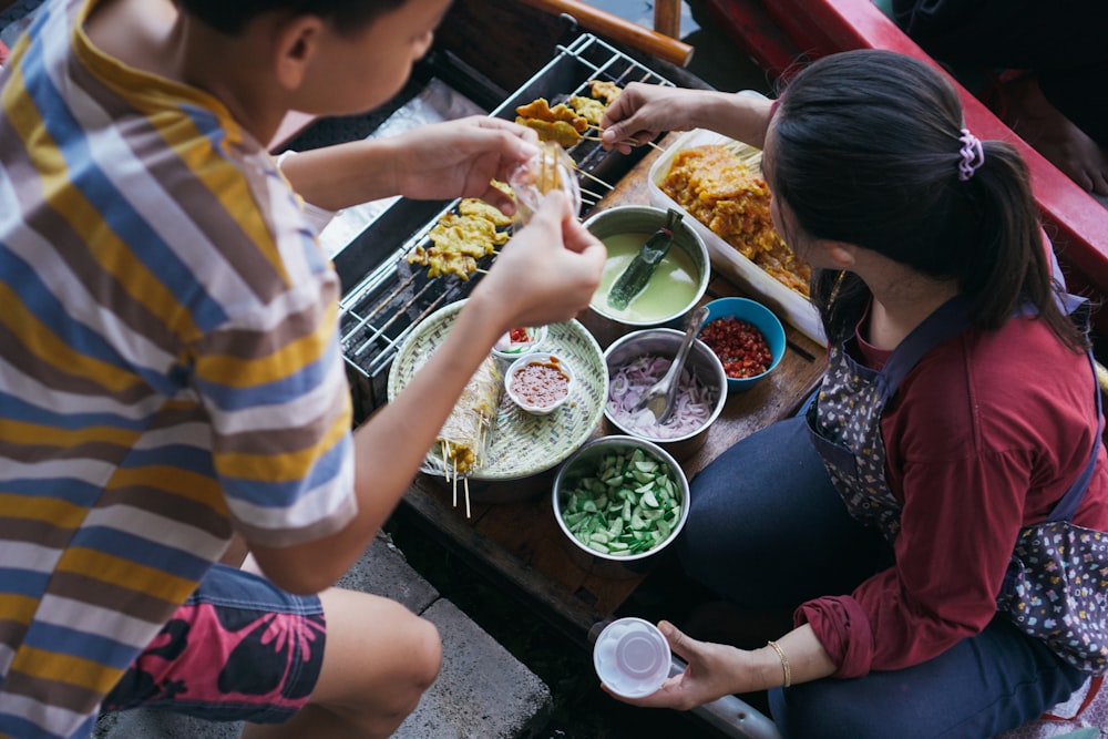 食べ物でいっぱいのテーブルの周りに座っている人々のグループ