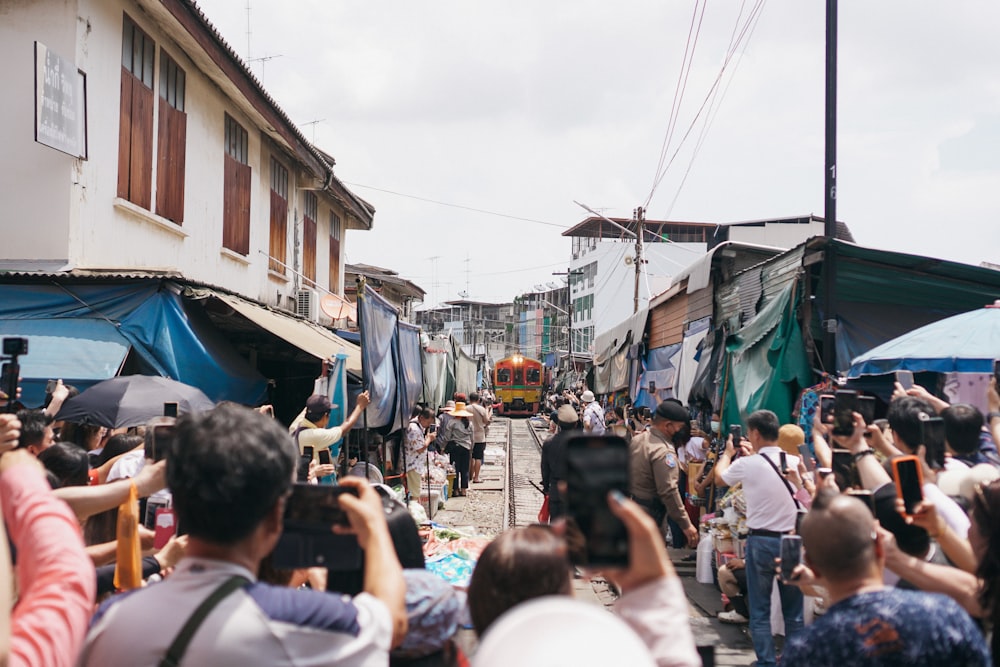 a crowd of people walking down a street next to buildings