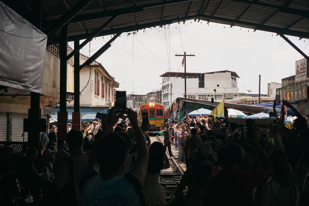 Una multitud de personas de pie alrededor de una estación de tren