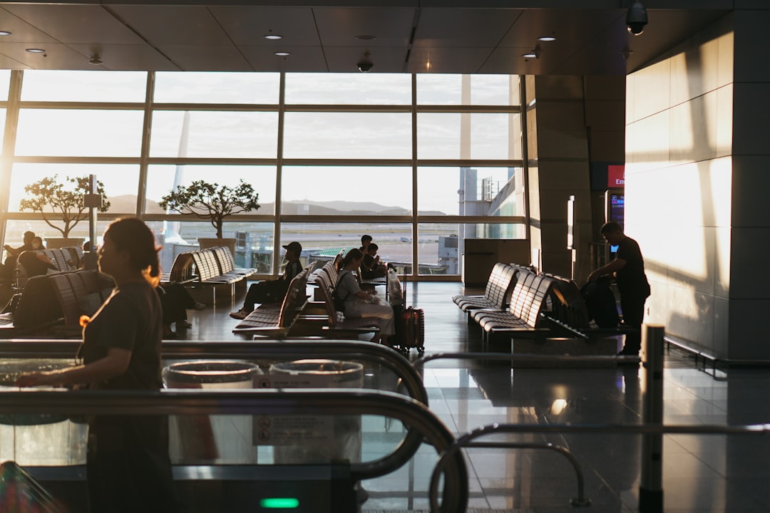 a man sitting in an airport waiting for his luggage,