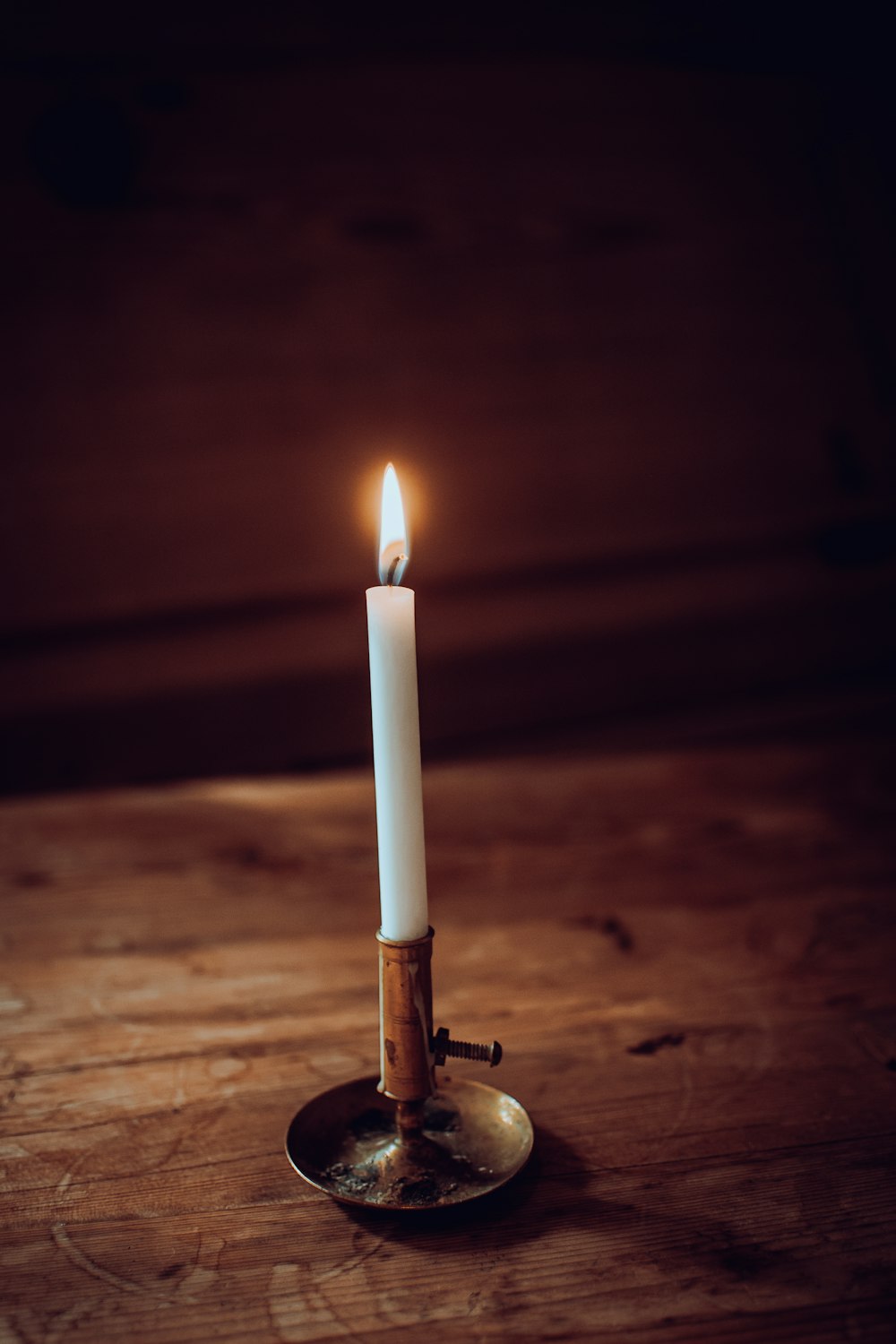 a lit candle sitting on top of a wooden table