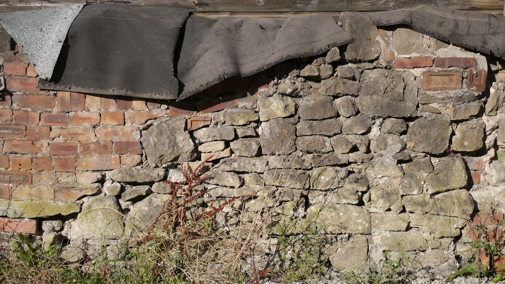 a stone wall with a black umbrella attached to it