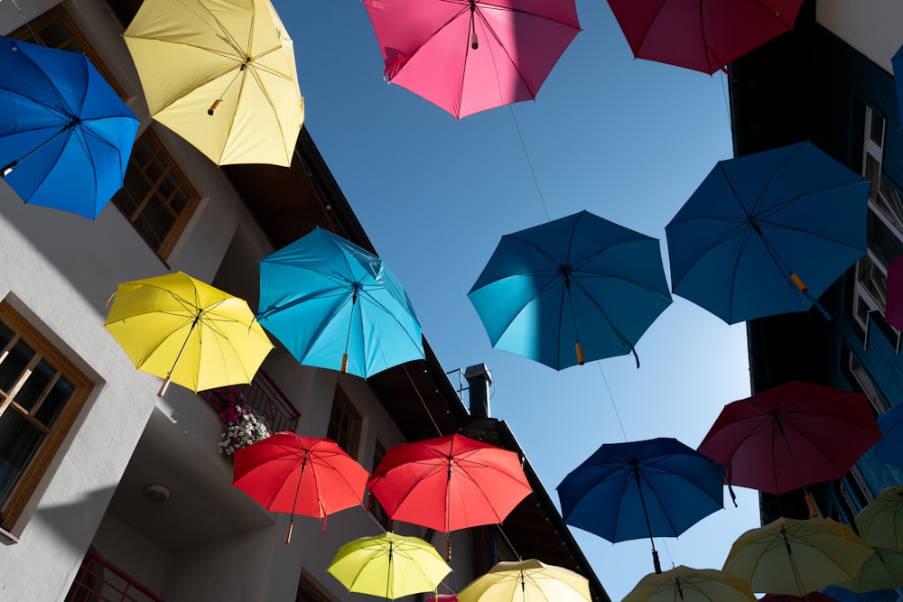 a group of multicolored umbrellas hanging from a building