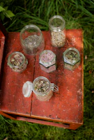 a wooden table topped with jars filled with food