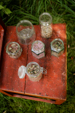 Bright jars of dehydrated ginger and garlic powders arranged on a wooden table with fresh roots nearby
