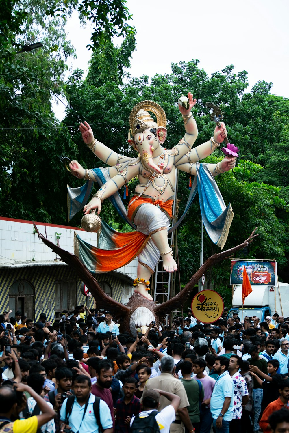 a crowd of people watching a statue of a god