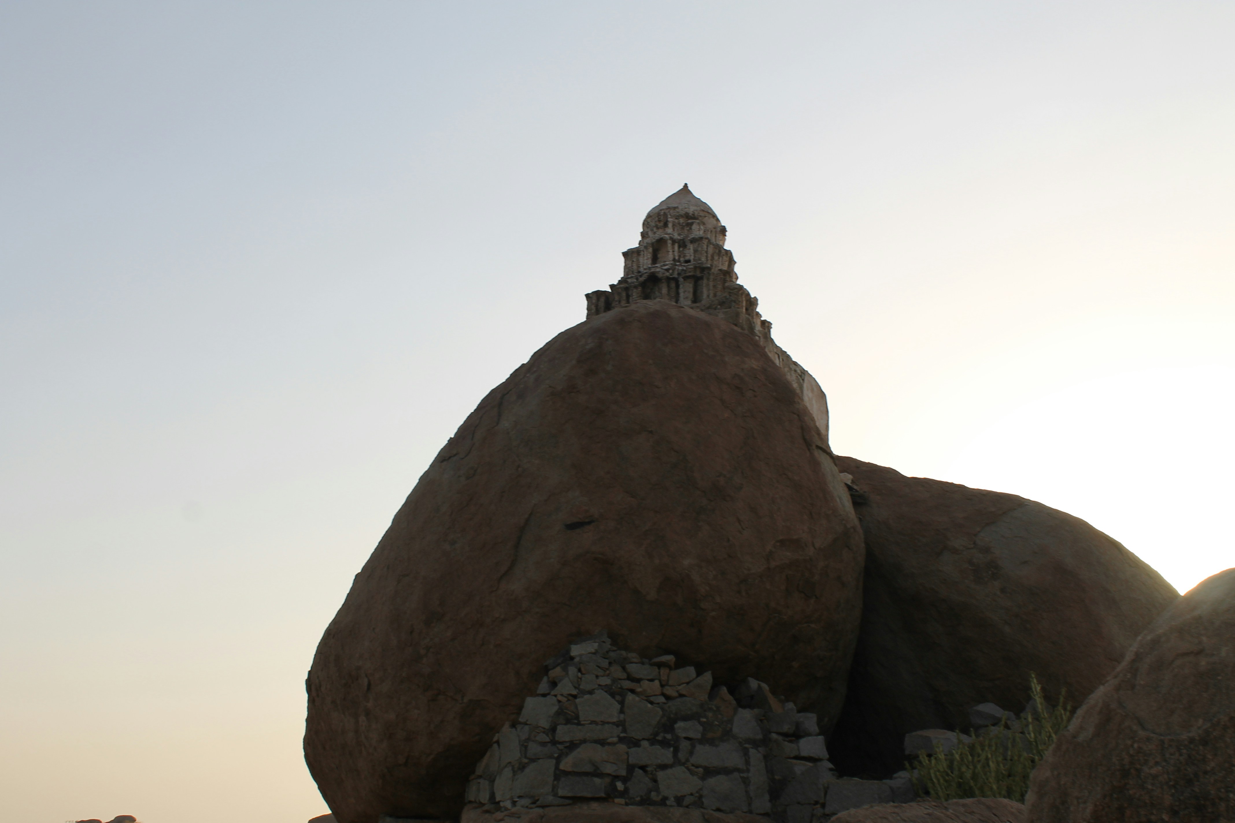 a large rock with a building on top of it