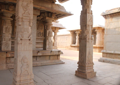 Intricately carved temple pillars made from premium granite, bathed in soft natural light.