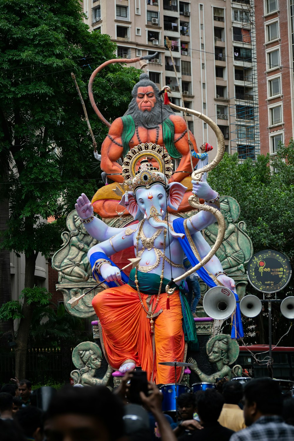 a large statue of a hindu god surrounded by people