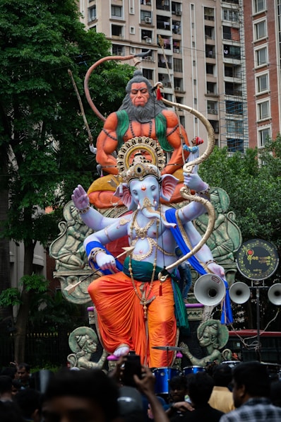 a large statue of a hindu god surrounded by people