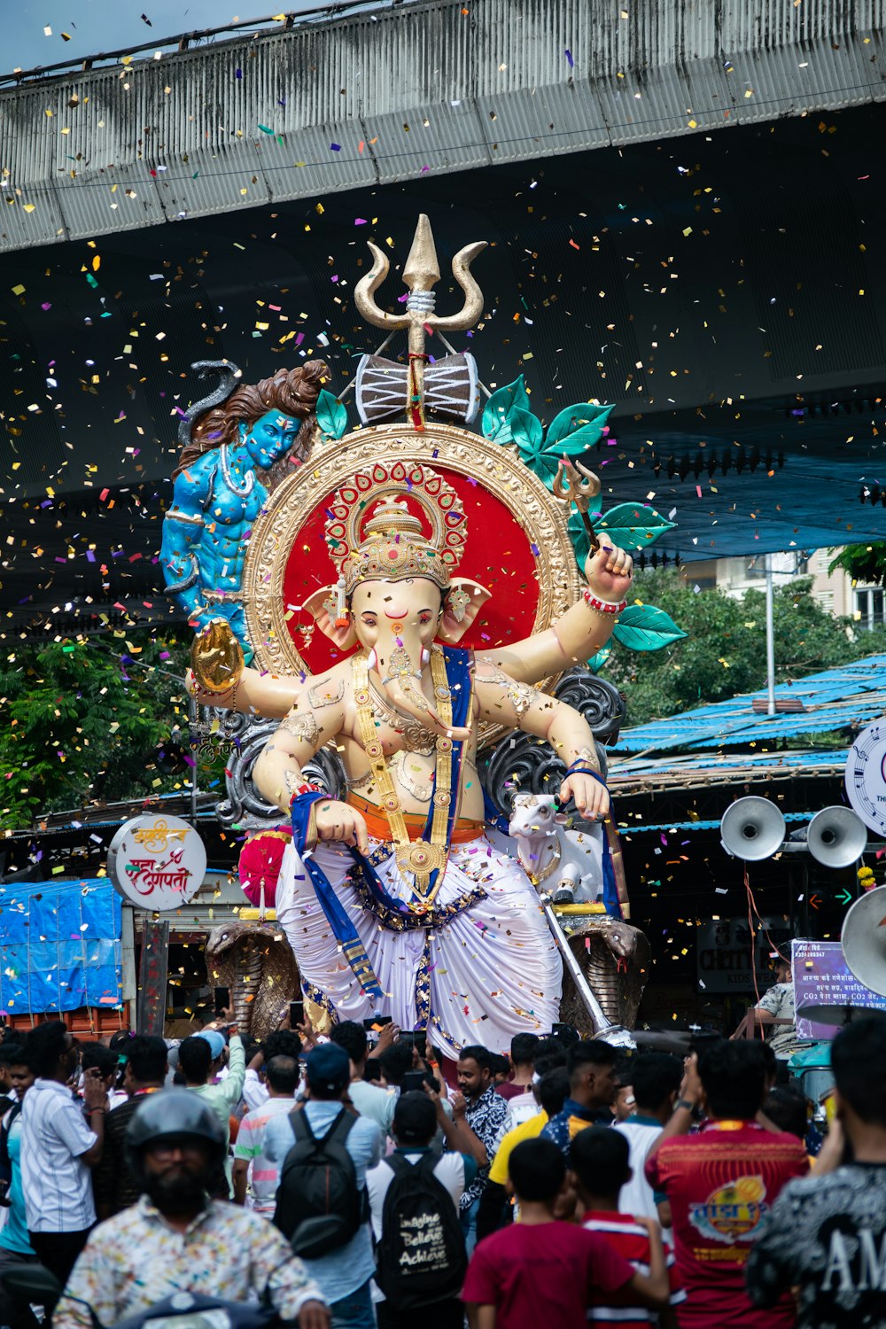 a large statue of a hindu god surrounded by confetti