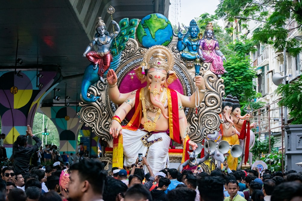 a crowd of people watching a statue of lord ganesh