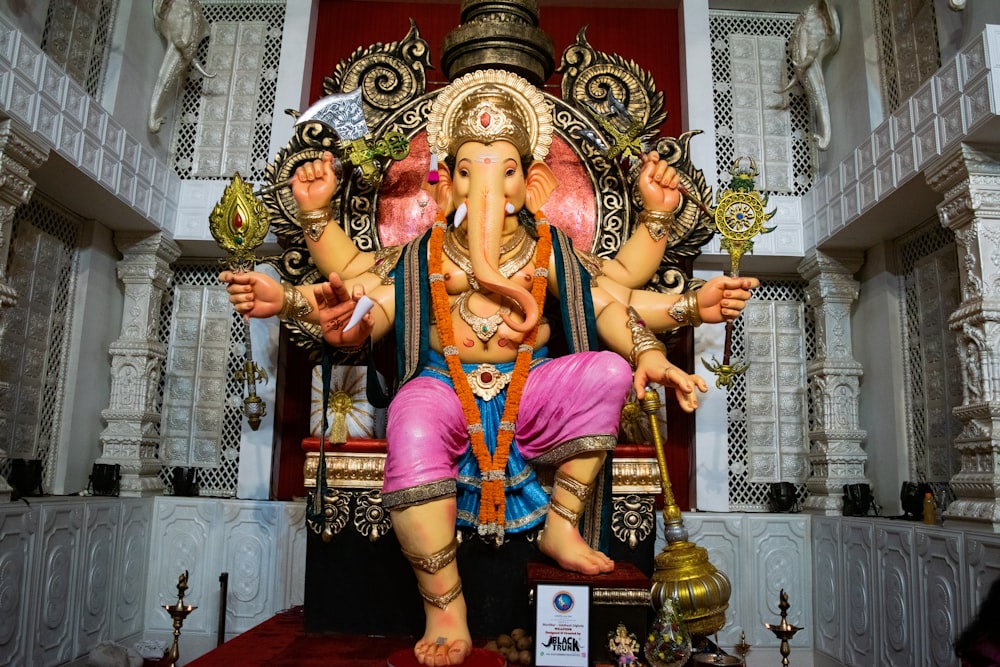 a statue of a ganesh sitting on a chair