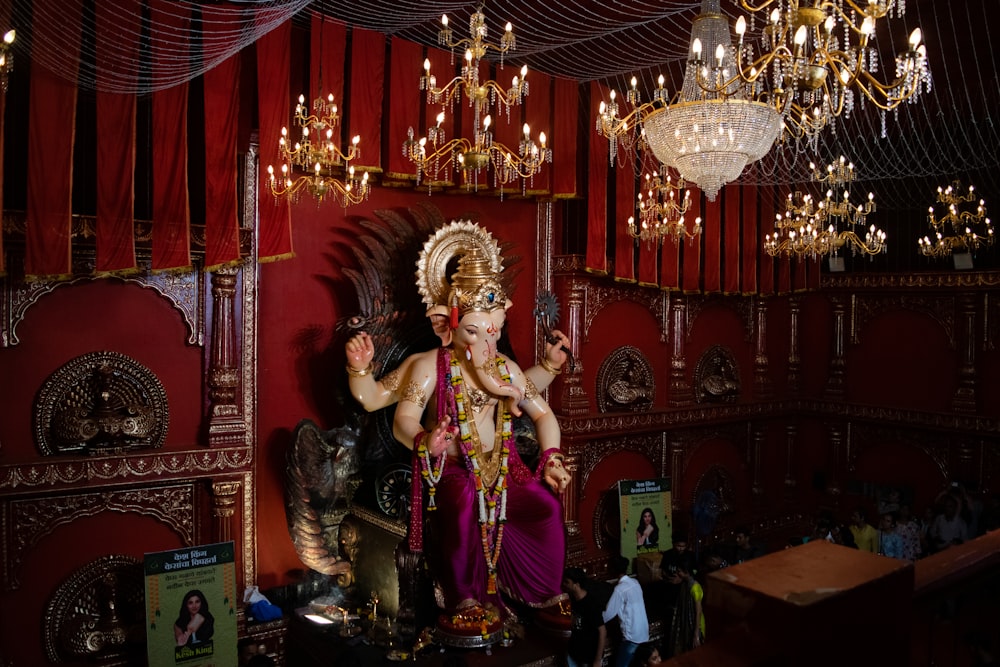 a statue of a person in a room with chandeliers