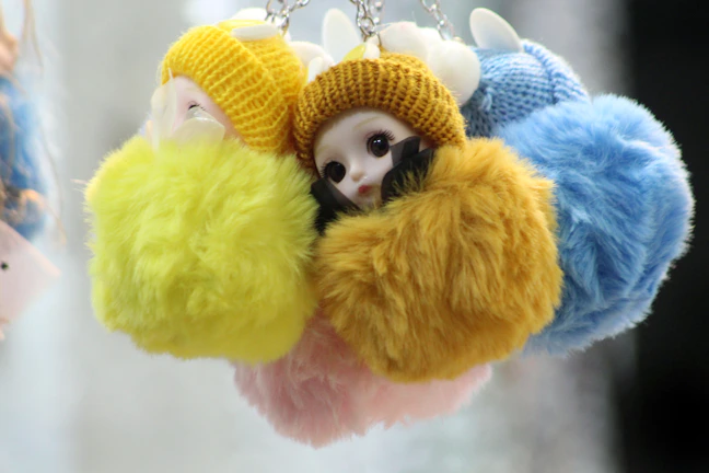 Cute mobile charms and keychains displayed on a light pink surface with subtle sparkles.