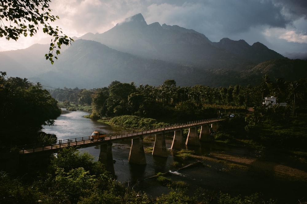 a bridge over a river with mountains in the background