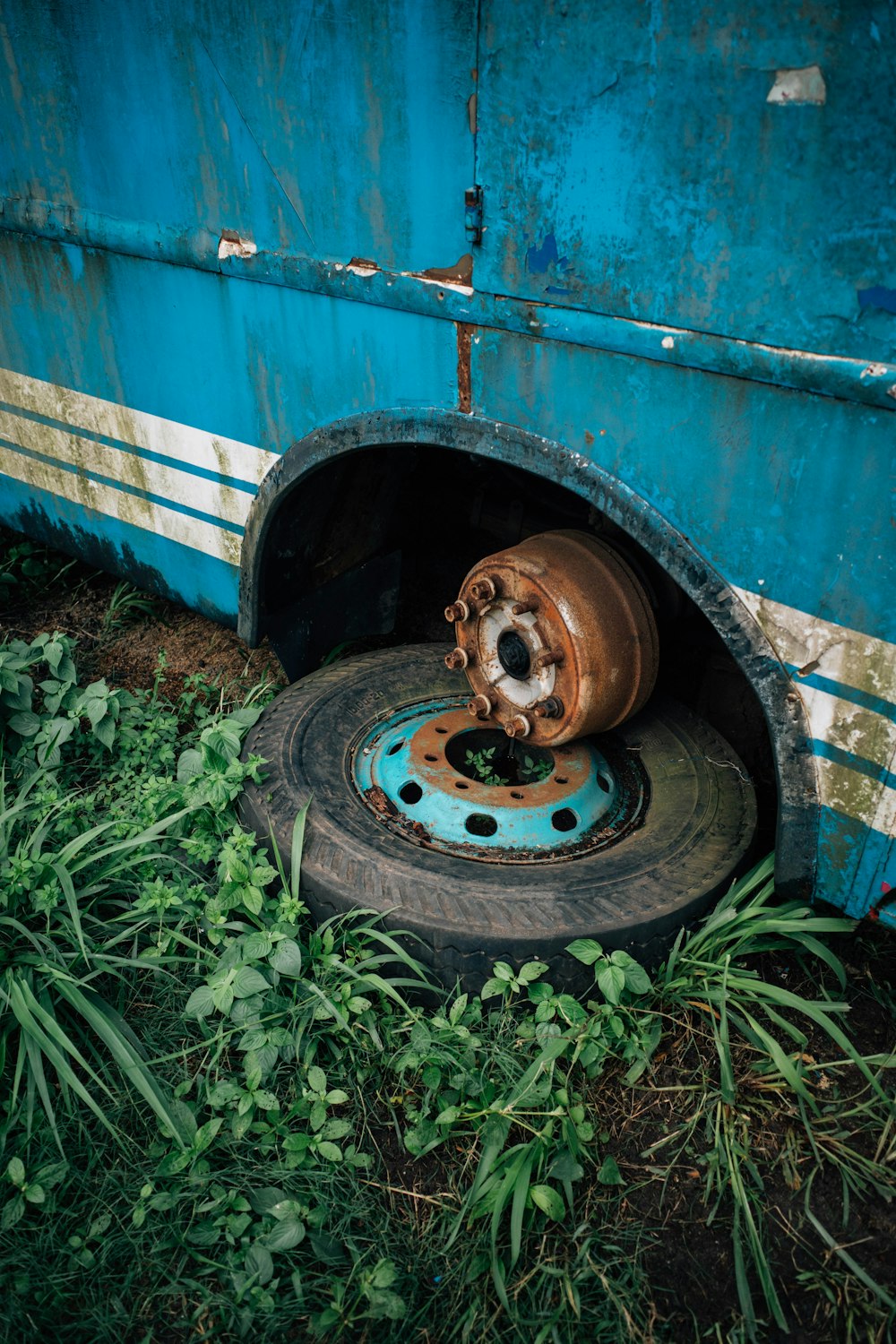 an old rusted tire sits in the middle of a field