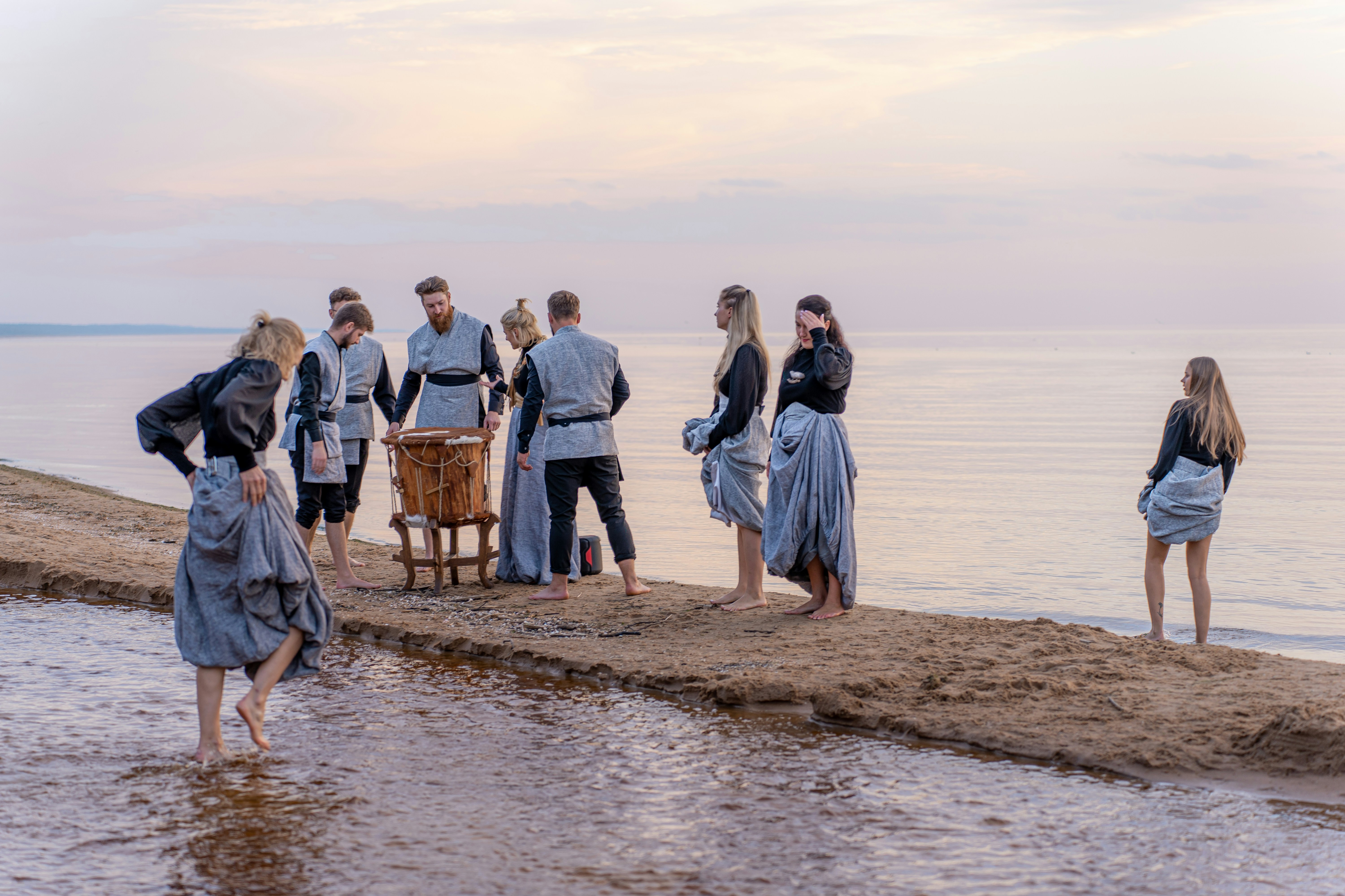 a group of people standing on top of a sandy beach