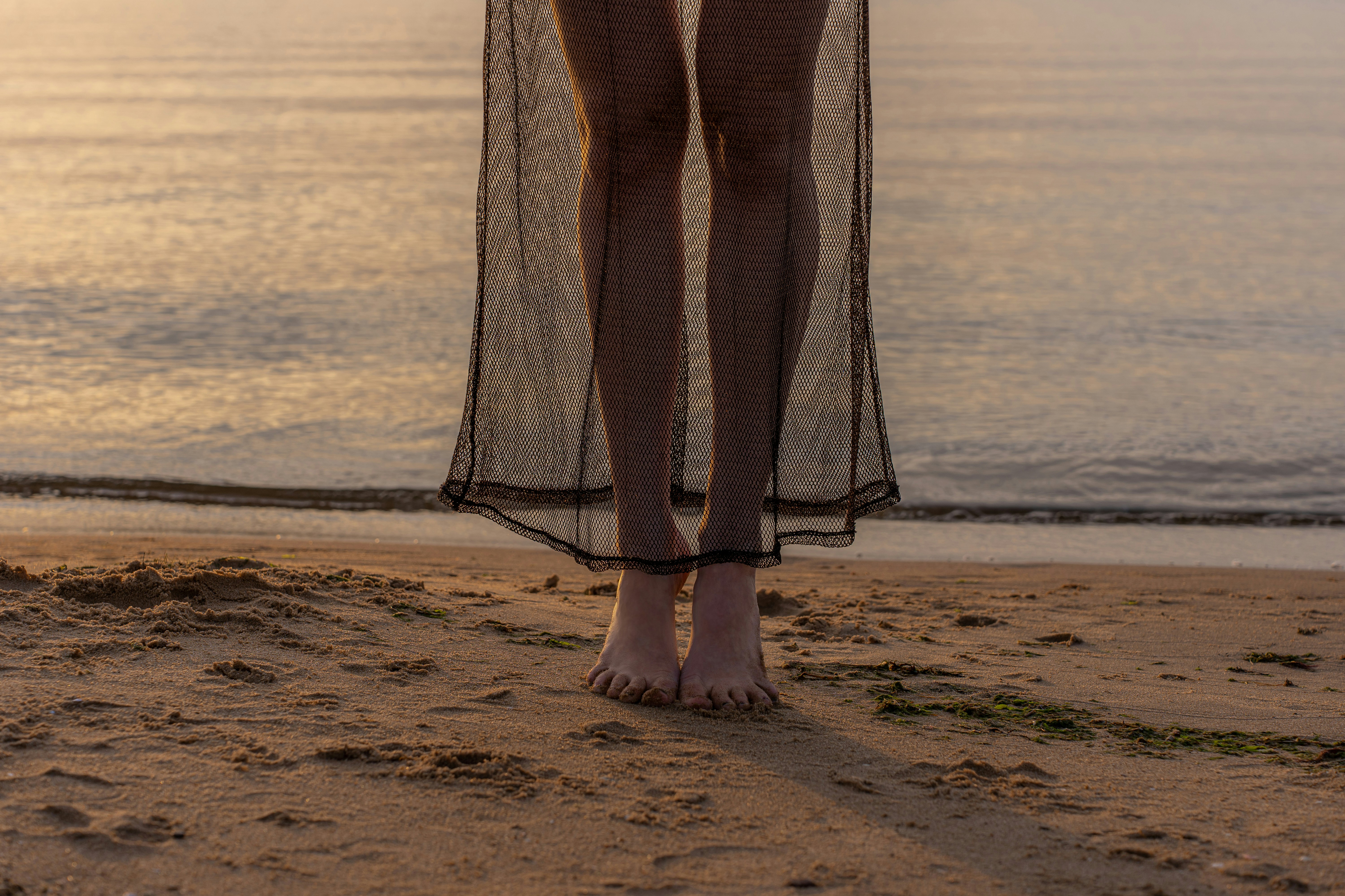 a woman standing on a beach next to the ocean