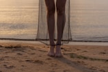 A serene moment of a dancer barefoot on sandy shore, bathed in golden light.