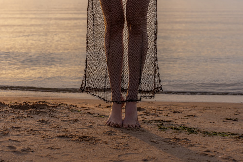 a woman standing on a beach next to the ocean