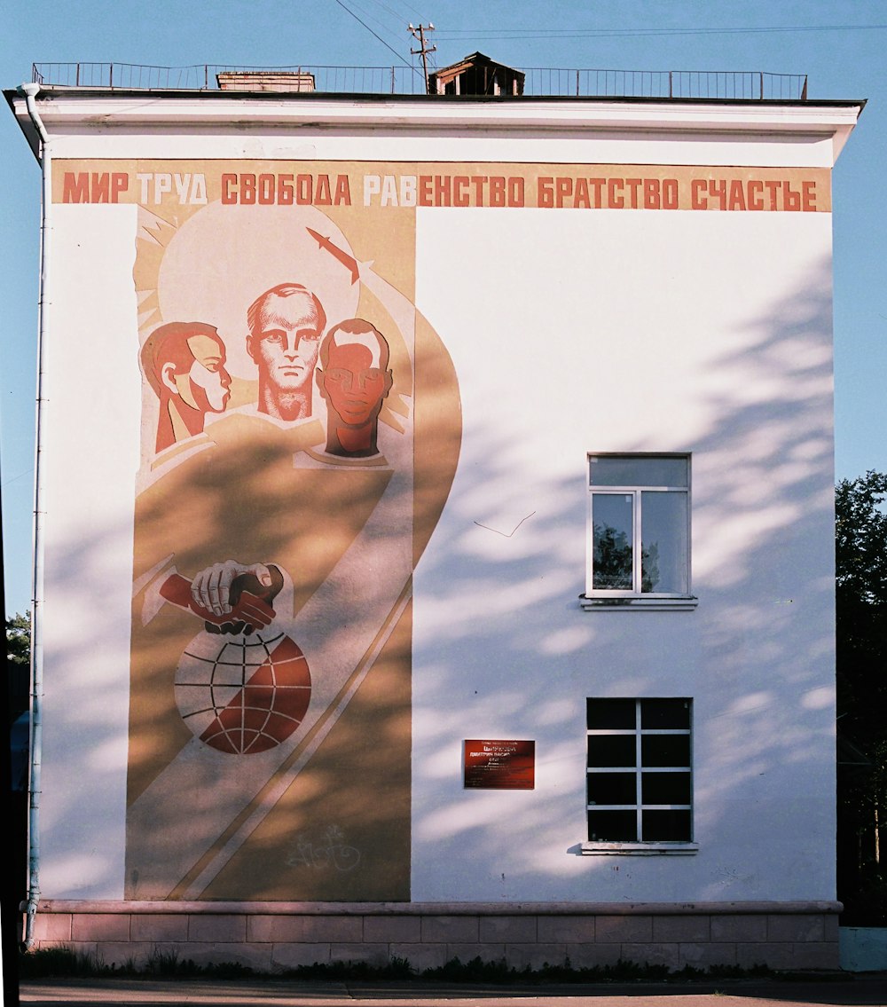 a white building with a large mural on the side of it