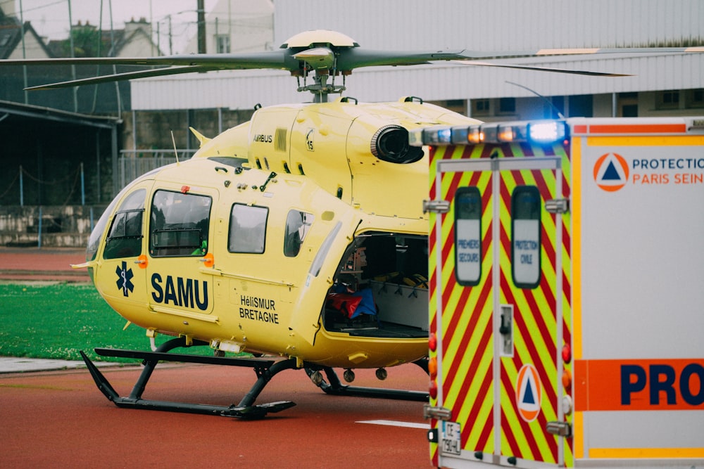 a large yellow helicopter parked next to an ambulance