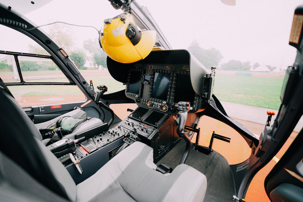 the cockpit of a helicopter with a yellow helmet on