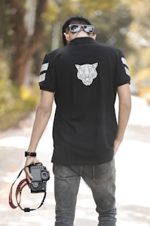 Lifestyle photo of a person wearing a r.a. polo shirt while enjoying a sunny day at the park