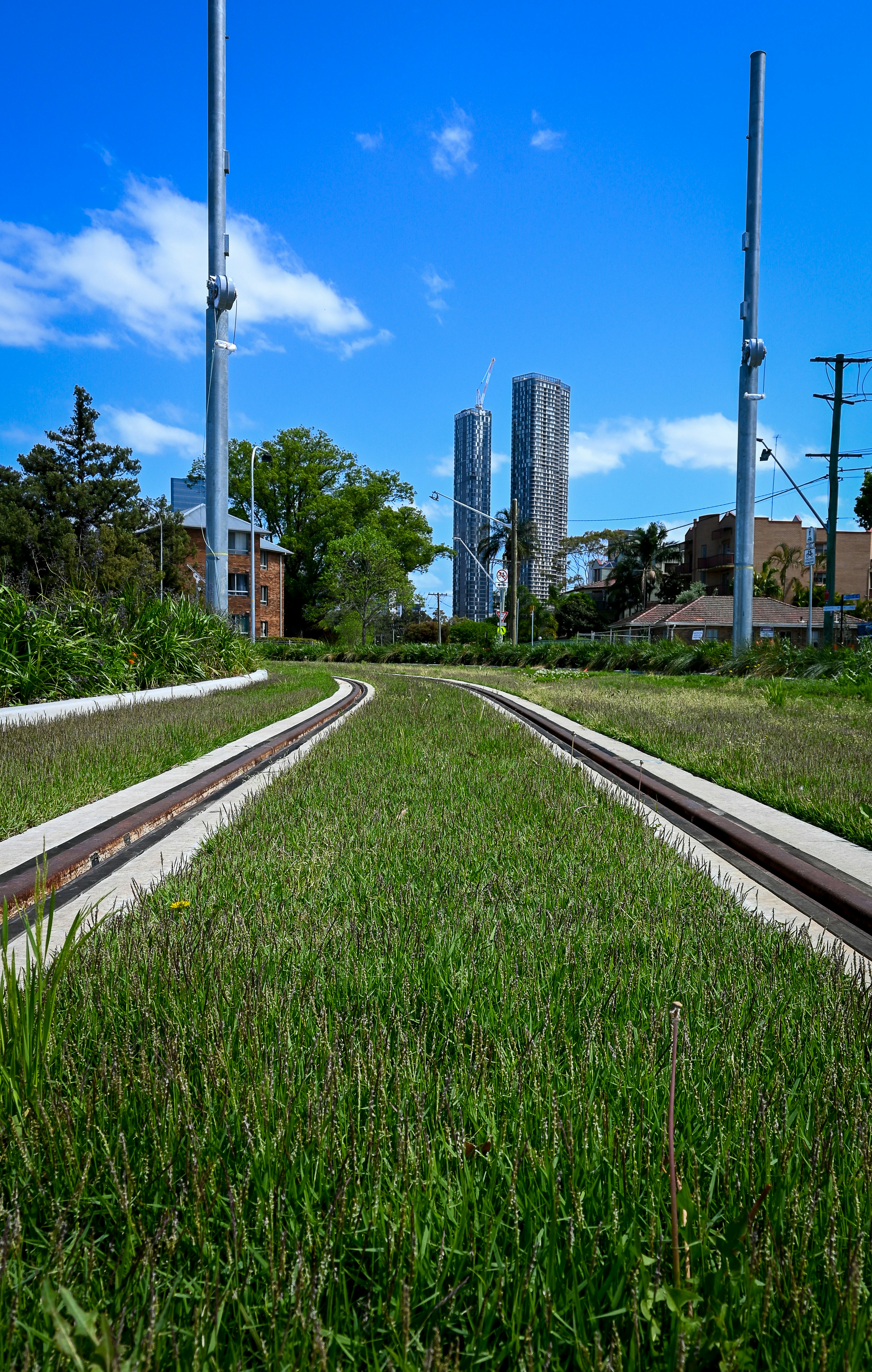 A train track running through a lush green field photo Free Tramway