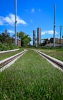 a train track running through a lush green field