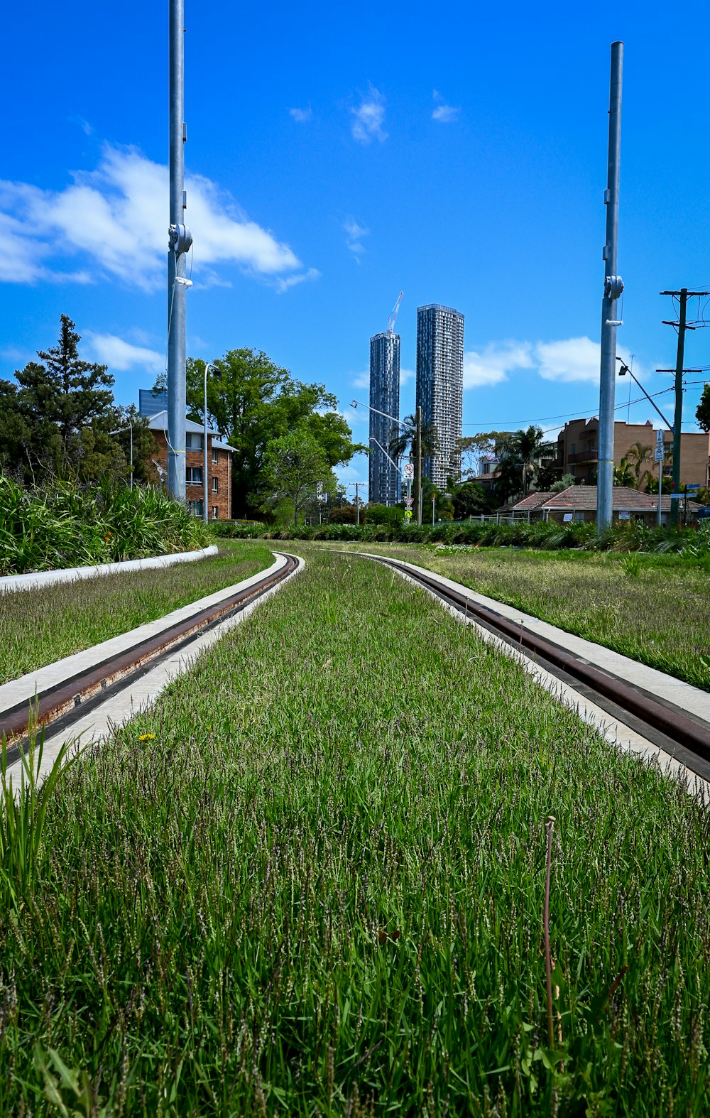a train track running through a lush green field