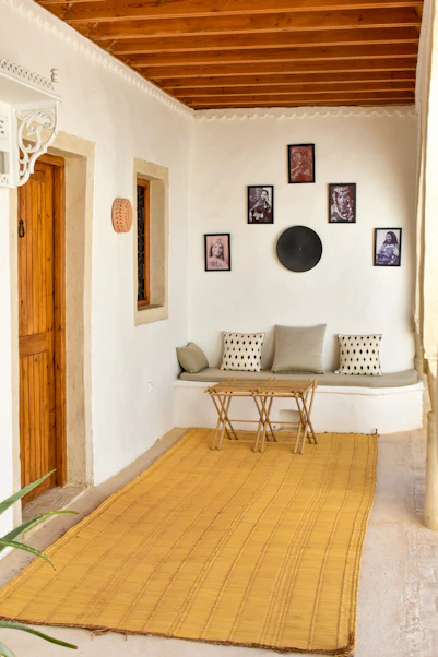 a living room with a rug and pictures on the wall