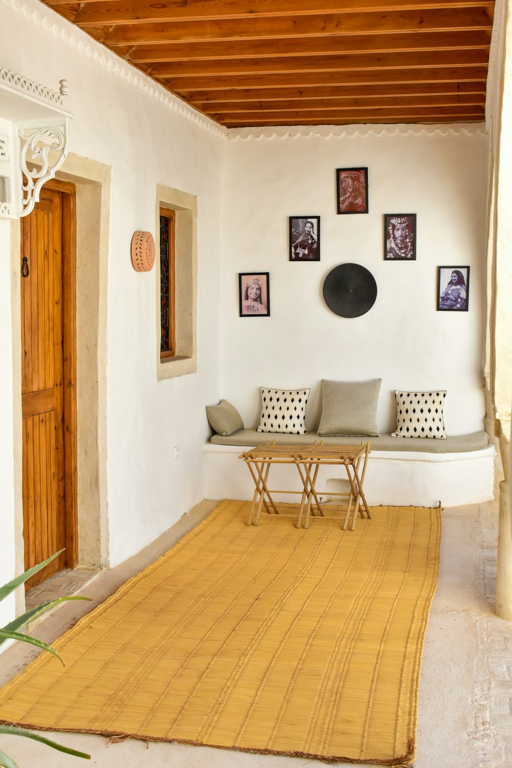 a living room with a rug and pictures on the wall