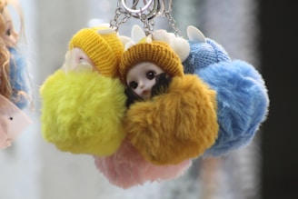 A charming crochet keychain shaped like a tiny pastel-colored animal, held in a hand.