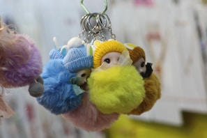 A collection of plush keychains arranged neatly on a pastel-colored fabric, highlighting their rounded shapes