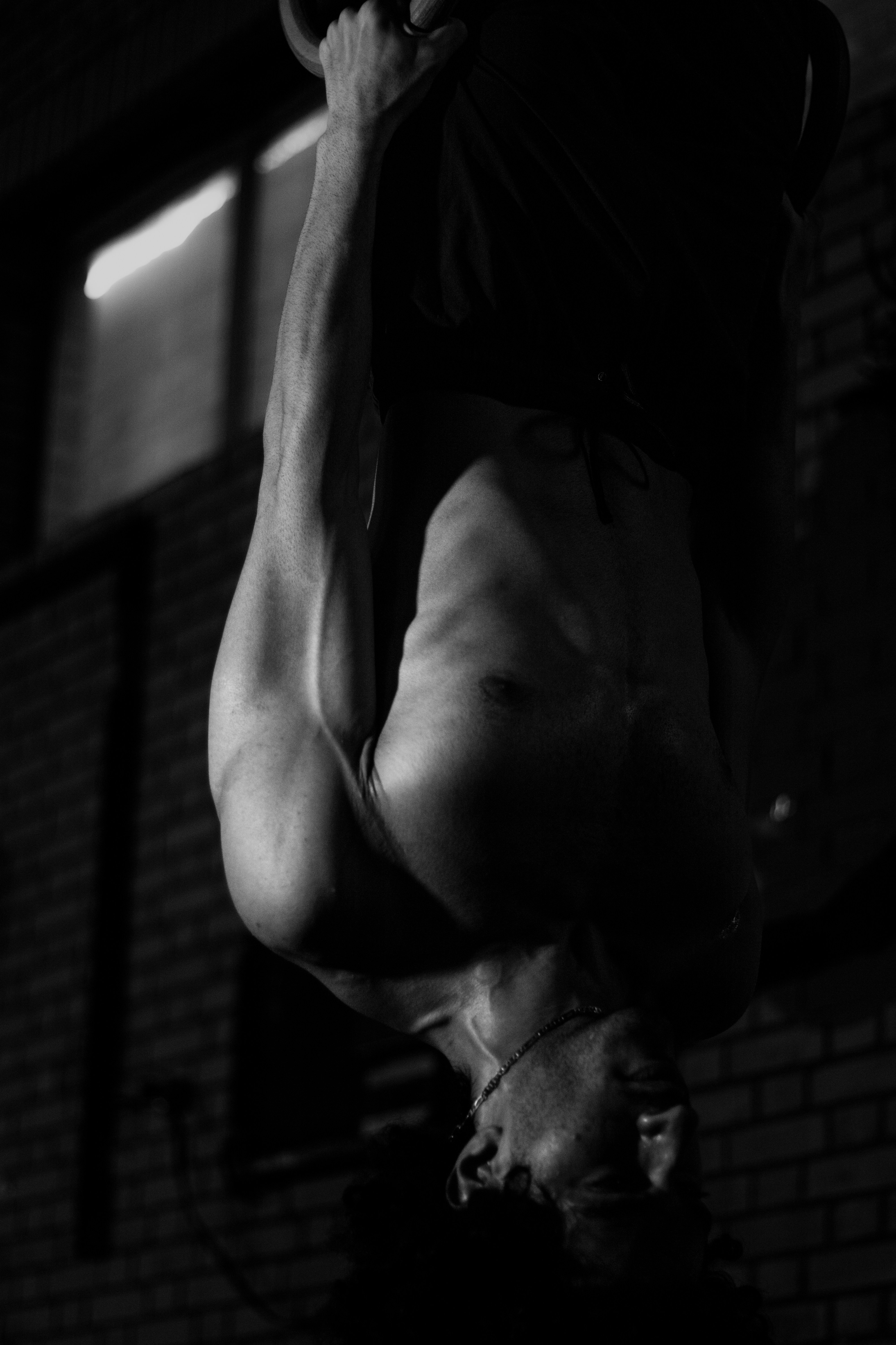 Un hombre haciendo una parada de manos en una pared de ladrillos