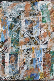 A vibrant abstract collage composed of mixed media elements, including layers of text, paint, and various textures. The composition features a mix of swirling patterns and bold brushstrokes, with parts of printed text appearing through the layers. The color scheme includes earthy tones with blues and greens, along with metallic accents.