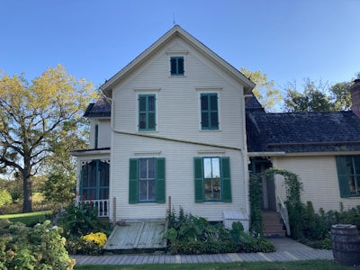 A charming colonial-style home with colorful shutters and a garden.