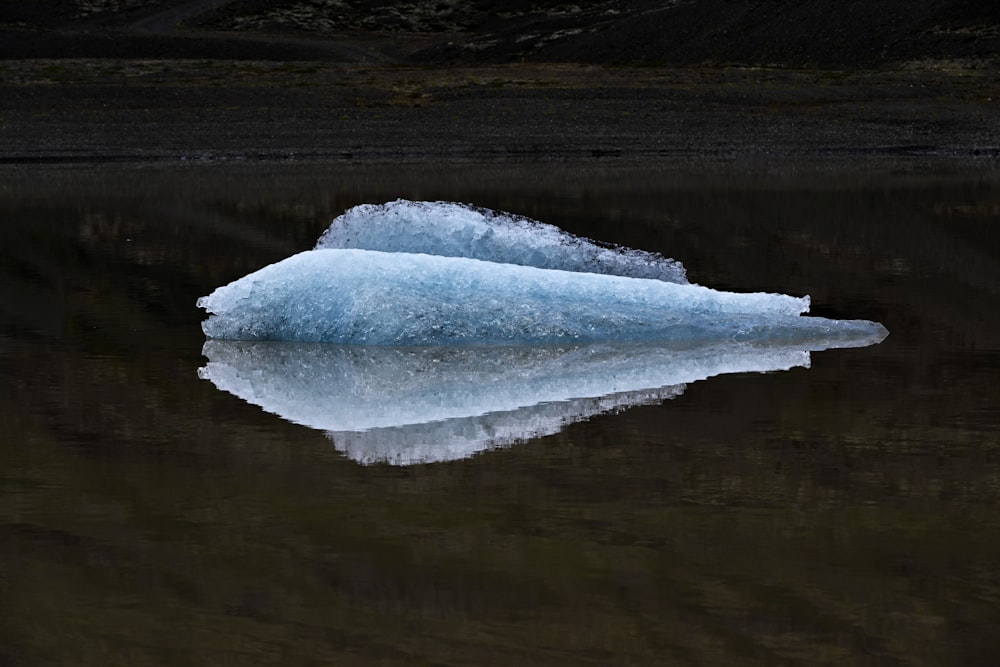 a large iceberg floating on top of a lake
