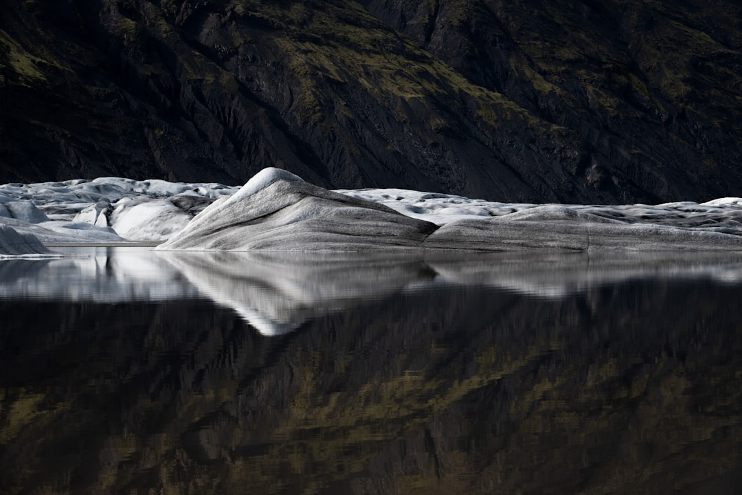 a large body of water with a mountain in the background,