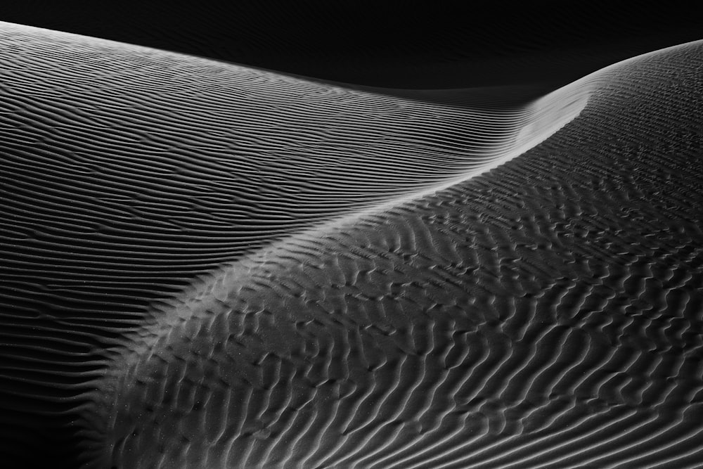 a black and white photo of a sand dune