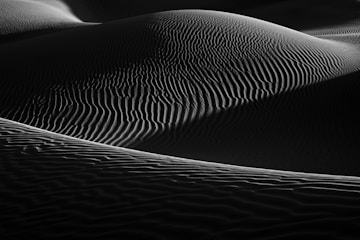 a black and white photo of sand dunes