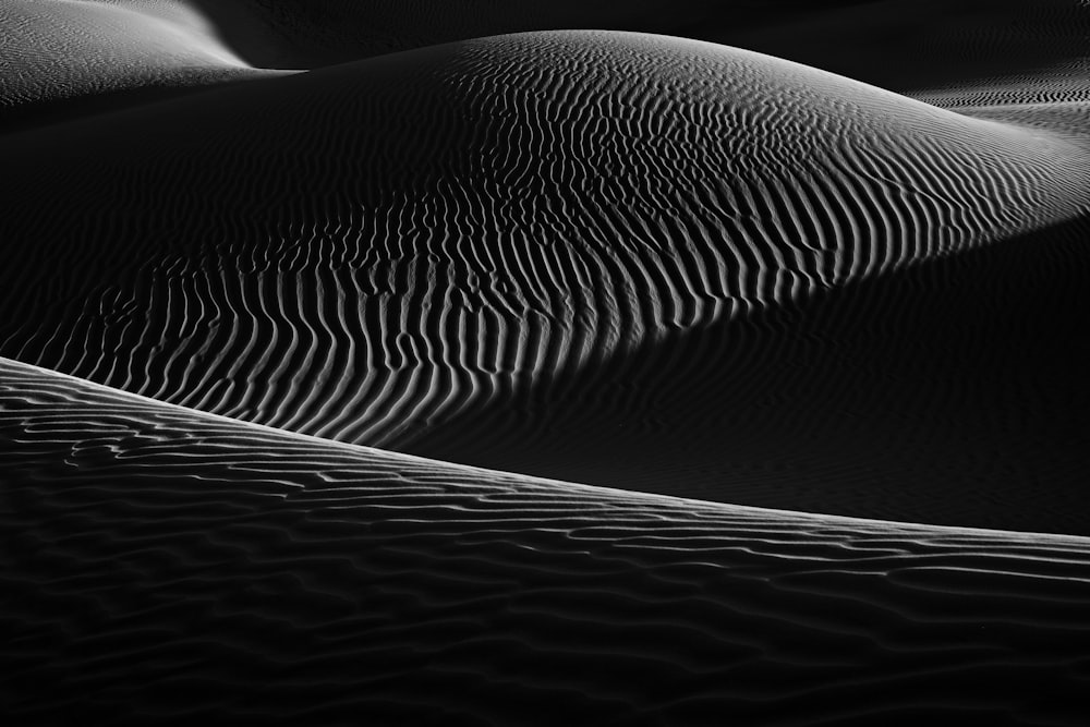 a black and white photo of sand dunes